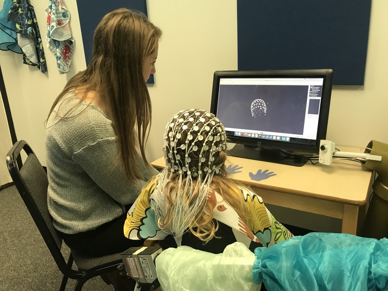 Child looking at a scan of their brain with a researcher.